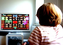 A young girl playing Pac-Man Championship Edition Girl plays Pac Man.JPG