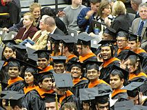 Multi-colored tassels, cords and stoles are noticeable over black graduation robes. Graduating students.JPG