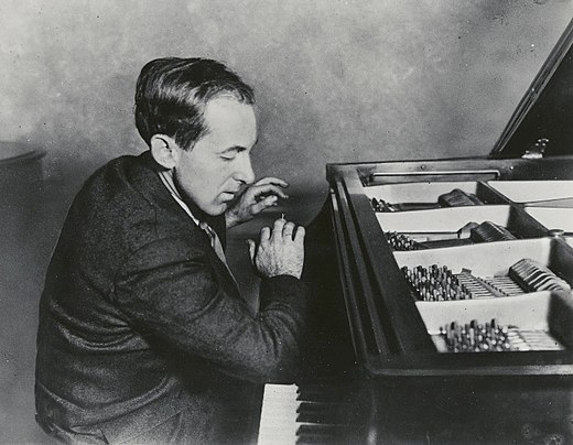 Cowell playing the piano, demonstrating his "forearm" technique by slamming down with his right arm on the middle register, c. 1920s