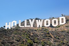 Photographie en contreplongée du panneau Hollywood, sous un ciel ensoleillé.