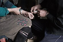 A drug user receiving an injection of the opiate heroin Injecting heroin.jpg