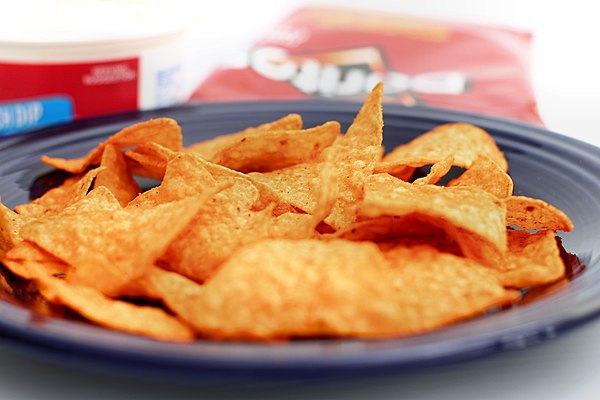 The current Doritos logo (top); Nacho Cheese Doritos (bottom).