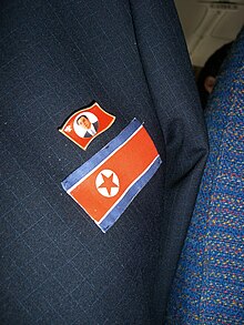 A Kim Il Sung badge and a North Korean flag emblem on a jacket North Korea -- Kim Il-sung Pin (1028141696).jpg