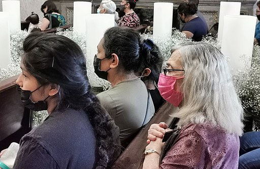 Persona con cubrebocas orando en iglesia durante pandemia de COVID-19 en México