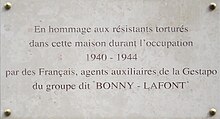 Plaque commémorative portant l'inscription « En hommage aux résistants torturés dans cette maison pendant l'occupation, 1940-1944, par des Français, agents auxiliaires de la Gestapo du groupe dit "Bonny-Lafont" »