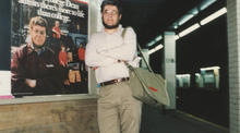 Dean Robert E. Pollack in front of a Columbia College poster, 1985 Robert Pollack at the NYC Subway Station.webp