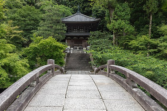 Stone bridge leading to a cemetery surrounded by trees in the compounds of Chion-in Kyoto Japan