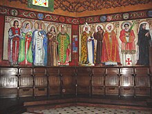 Vue de deux murs à angle droit couverts des fresques représentant des personnages religieux.