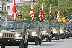Viewing march by JGSDF regiment vehicle troops with the flag of the Japan Self-Defense Forces