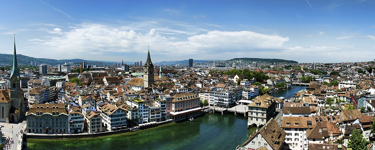 https://upload.wikimedia.org/wikipedia/commons/thumb/c/cf/1_zurich_panorama_grossmunster_limmat_river_2012.jpg/1280px-1_zurich_panorama_grossmunster_limmat_river_2012.jpg