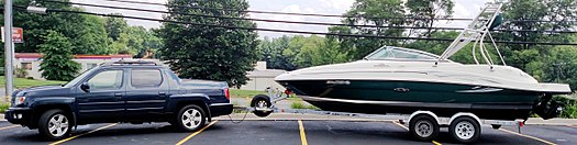 2009 Ridgeline RTL—with OEM roof rack,[79] body-side molding,[88] splash guards,[89] and brush guard[90]—towing a 2005 Sea Ray 220 Sundeck sport boat with wakeboard tower