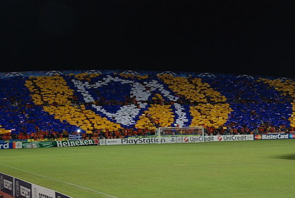 The club's colours and badge displayed by APOEL fans in the 2009–10 Champions League match against Chelsea.