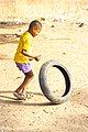 A Young Ghanaian child Rolling motorcycle tyre.jpg