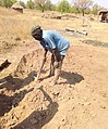 A_man_digging_the_sand_to_be_used_for_building_thatch_rooms_in_Northern_Ghana