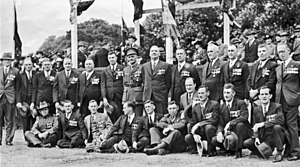 Uma fotografia em preto e branco de grupo de homens vestindo ternos e medalhas