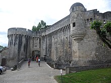 Színes fénykép egy impozáns késő középkori kővár faláról és kapujáról