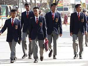 Meninos birmaneses em seu uniforme escolar com paletó e gravata.