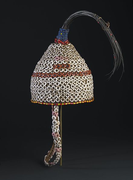 This hat would only have been worn by initiates to Kindi, the highest level of Bwami. Tail hair of an elephant, a metaphor for Kindi, crowns the hat. European-made buttons began to replace cowrie shells as prestige items on such Bwami paraphernalia as the Western presence grew in eastern Congo in the early twentieth century