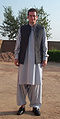 Bildet viser vanlig herreantrekk for pashtunere i Afghanistan og Pakistan. Mannen bærer Salvar kamíz med vide bukser og sid skjort med vest eller ermeløs jakke.