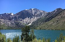 Convict Lake in late June, with its characteristic turquoise-blue color. The snow and ice is still present around the mountain top and melting into a stream that feeds the lake near the base of the mountain. Convict Lake & Laurel Mountain, 2019b.jpg