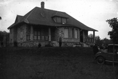 Photographie en noir et blanc d'une maison en campagne.