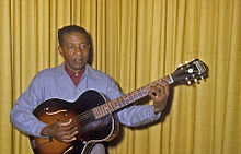 Lonnie Johnson posing with his guitar