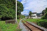 三峰口駅構内の引き上げ線。旧橋のアンカレイジと取り付け道路の踏切が残されている。