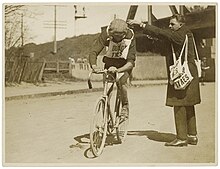 A cyclist is given a musette (ca. 1925 - 1940). Musette - Dunlop Tyres.jpg