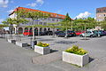 Richtstein, eingelassen in den Boden in Prenzlau (Uckermark) am Markt. Im Hintergrund Parkplatz am Markt sowie das Hotel Uckermark.