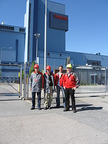 Four employees of Ruukki before the rolling mill in Hameenlinna Ruukki Hameenlinna.jpg