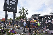 Secretary of Homeland Security Jeh Johnson visits Pulse and the makeshift memorial outside of it on the three-month anniversary of the shooting Secretary Johnson pays Respect at Pulse Nightclub (29619443211).jpg