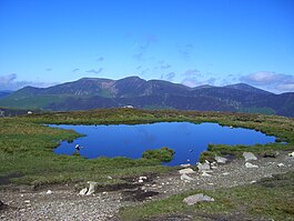 View west to the Grasmoor group of hills from the small tarn on the summit ridge. Summit tarn on High Spy.jpg