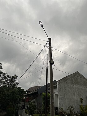 Tiang listrik di perumahan Cilebut Residence Bogor (Indonesia), menyalurkan energi listrik yang berasal dari batu bara (bahan bakar fosil).