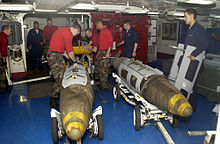 Attaching a GPS guidance kit to a dumb bomb, March 2003. US Navy 030319-N-4142G-020 Ordnance handlers assemble Joint Direct Attack Munition (JDAM) bombs in the forward mess decks.jpg