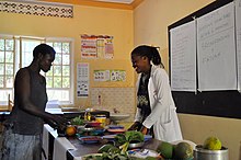 A caregiver teaches mothers with small children about nutrition at a hospital in Jinja, Uganda as part of a program funded by the Social Innovation Fund. Uganda Nutrition (40911014075).jpg