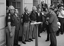 Wallace standing against desegregation while being confronted by U.S. Deputy Attorney General Nicholas Katzenbach at the University of Alabama in 1963 Wallace at University of Alabama edit2.jpg