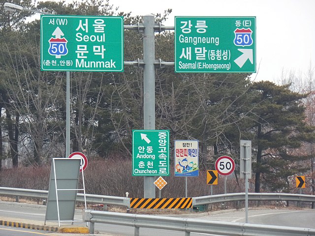 The Latin alphabet used in romanization on road signs, for foreigners in South Korea