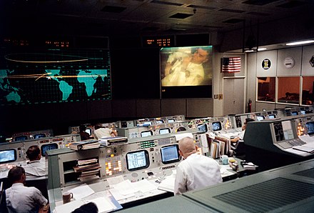 Mission Operations Control Room during the TV broadcast just before the Apollo 13 accident. Astronaut Fred Haise is shown on the screen.