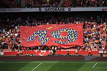 Stadion kerumunan memegang banner raksasa overhead menampilkan nomor 49