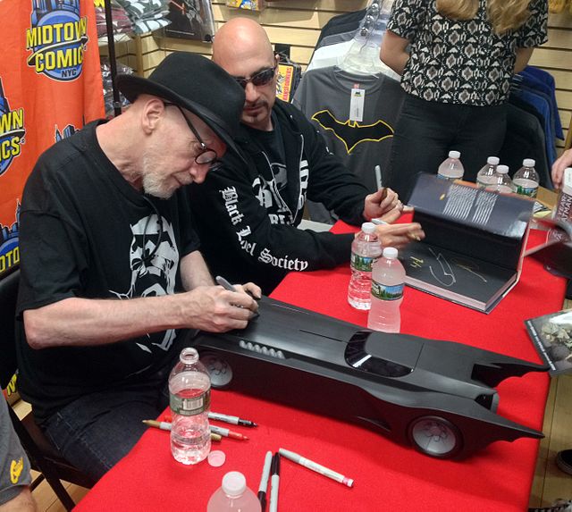 Comics creators Frank Miller and Greg Capullo sign a toy Batmobile based on the animated series during an appearance at Midtown Comics.