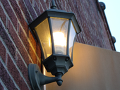 A CFL used outside of a building A CFL Light Bulb on a wall in a black lantern in South Carolina.PNG