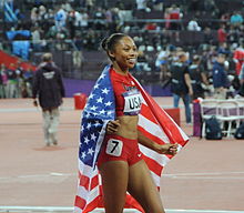 Photographie d'Allyson Felix tenant le drapeau américain