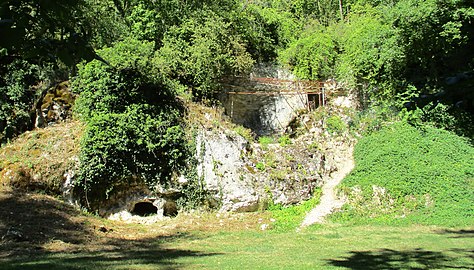 Sur la butte, grotte du Renne à droite et grotte du Bison à sa gauche sous le lattis rouge.