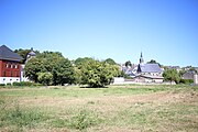 Une plaine, d'où l'on perçoit l'église, à Château-Renault