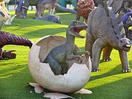 דגם של דינוזאור טורף בוקע מביצה בפארק הדינוזאורים של סינמה סיטי ראשון לציון