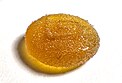 A circular yellow gummy viewed from the side