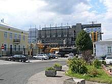 A colour photograph of the shale oil facility in Kohtla-Järve. The lower third of the photo is occupied by a curving driveway and the cars parked along it.
