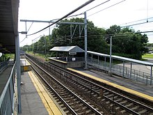 Uzun alçak platformları ve kısa uzunluklarda yüksek seviye platformları olan bir tren istasyonu