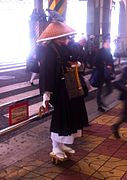 A Japanese monk wearing a sugegasa begs for money in Ueno, Tokyo