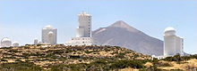 Kelkaj el la teleskopoj de la Observatorio de Tejdo. En fono, la vulkano Tejdo